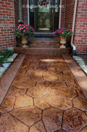 Stamped concrete Des Moines walkway leading to a brick house entrance.