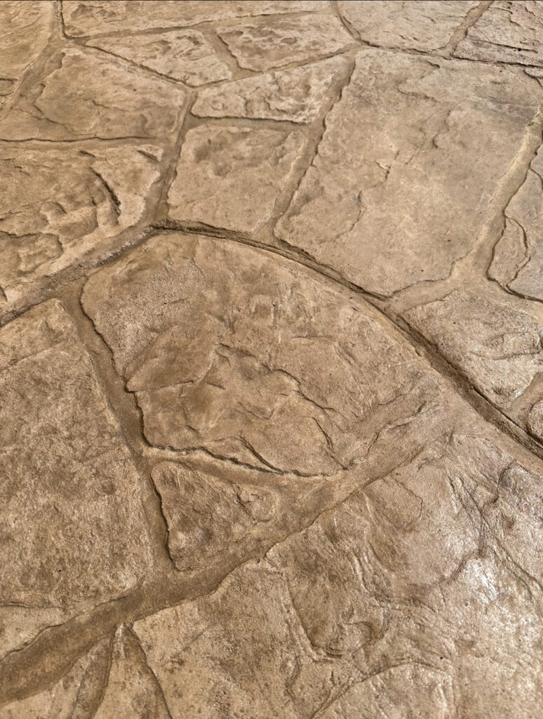 Textured concrete sidewalk with a flagstone pattern. Des Moines sidewalk replacement.